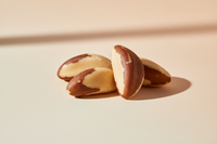 Minimalist premium product photo of brazil nuts, isolated on a light pastel background, natural lighting, macro focus, clean soft composition, modern wellness aesthetic.
